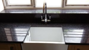 Butler sink with double draining grooves and integrated window ledge in Black Angola granite